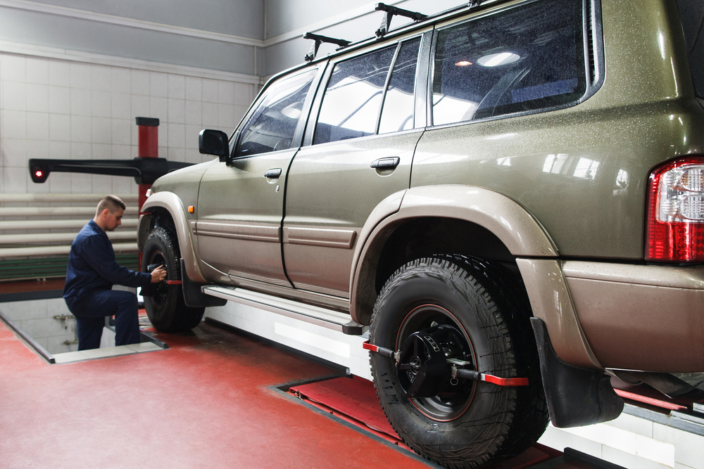 Wheel alignment for SUV in professional workshop. Modern auto service with high-level maintenance